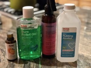 ingredients for homemade hand sanitizer: essential oil, glycerin and aloe vera gel, an empty spray bottle, and isopropyl alcohol above 60%