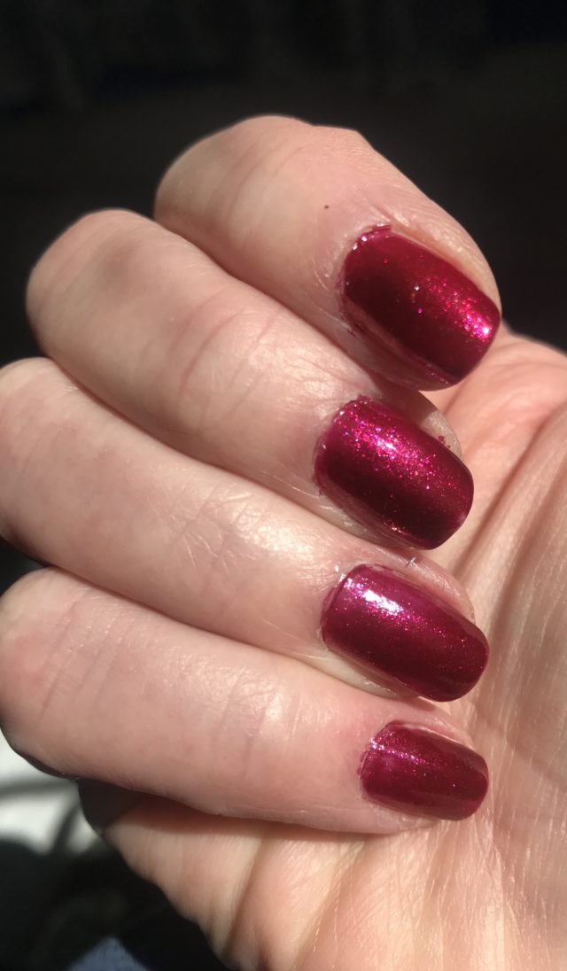 closeup of my fingers wearing metallic ruby red Zoya Sarah nail polish