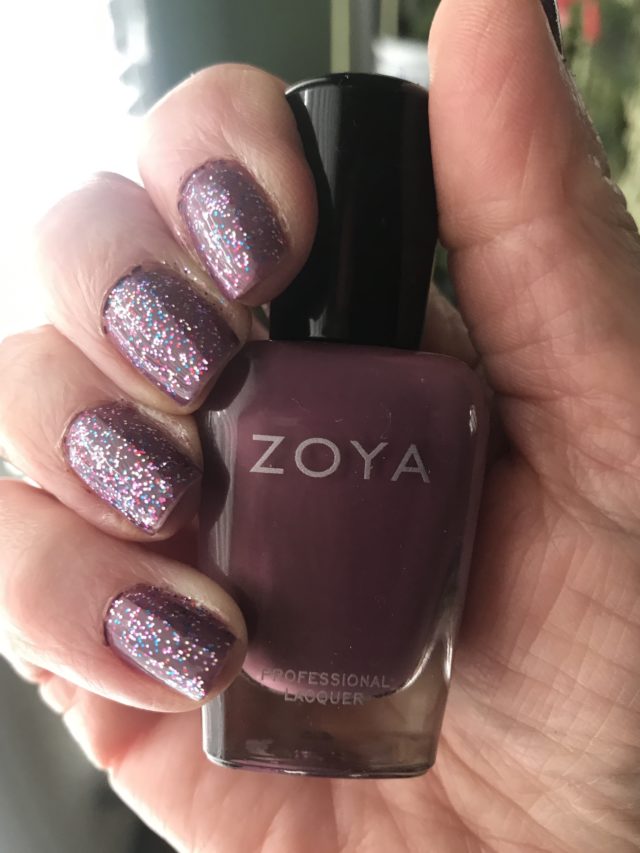 holding Zoya Joni, a dusty plum cream polish while wearing Poparazzi Seeing Sparkles glitter topper over it on my nails