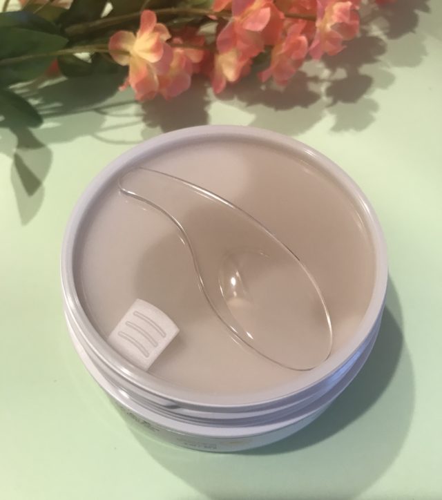the plastic cover inside the tub of Derma E Vitamin C Bright Eyes Hydrogel Patches tub to protect the patches as well as a plastic scoop for easy and clean application