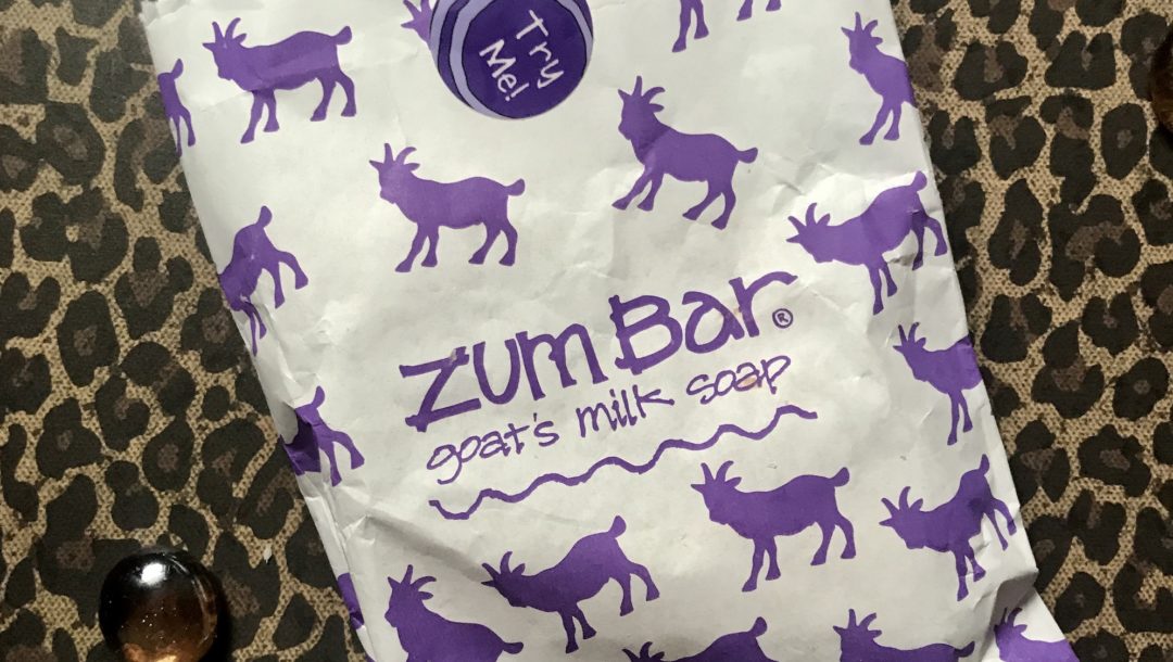 white paper bag that is decorated with fanciful pictures of purple goats on the Zum Bar soap white bag
