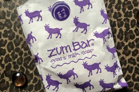 white paper bag that is decorated with fanciful pictures of purple goats on the Zum Bar soap white bag