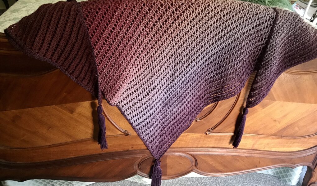 shades of purple Dragon Belly shawl draped over the footboard of my bed