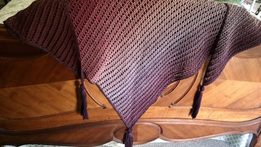 shades of purple Dragon Belly shawl draped over the footboard of my bed