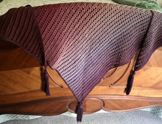 shades of purple Dragon Belly shawl draped over the footboard of my bed
